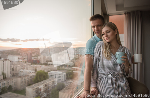 Image of young couple enjoying evening coffee by the window