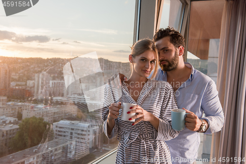 Image of young couple enjoying evening coffee by the window