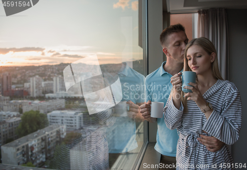 Image of young couple enjoying evening coffee by the window