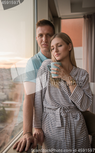 Image of young couple enjoying evening coffee by the window