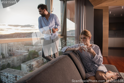 Image of young couple enjoying evening coffee by the window