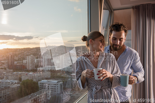 Image of young couple enjoying evening coffee by the window