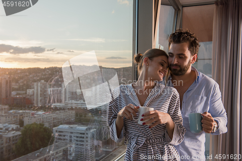 Image of young couple enjoying evening coffee by the window