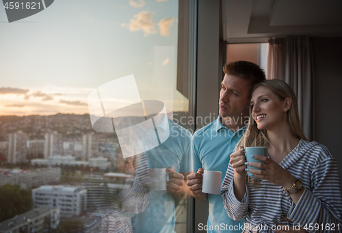 Image of young couple enjoying evening coffee by the window