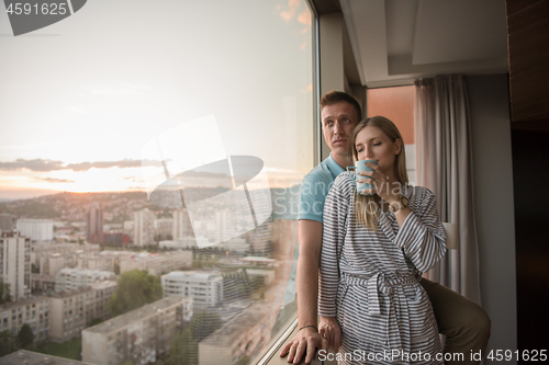 Image of young couple enjoying evening coffee by the window