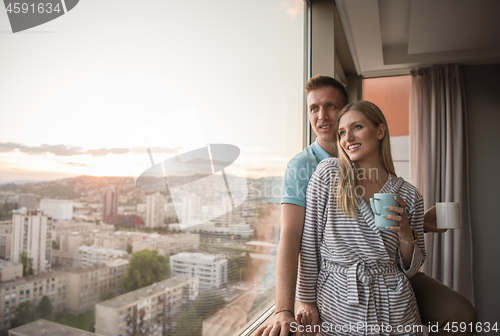 Image of young couple enjoying evening coffee by the window