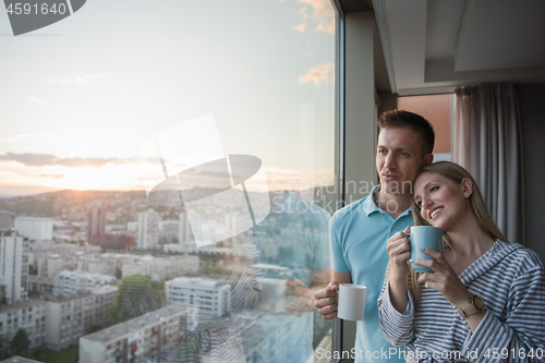 Image of young couple enjoying evening coffee by the window