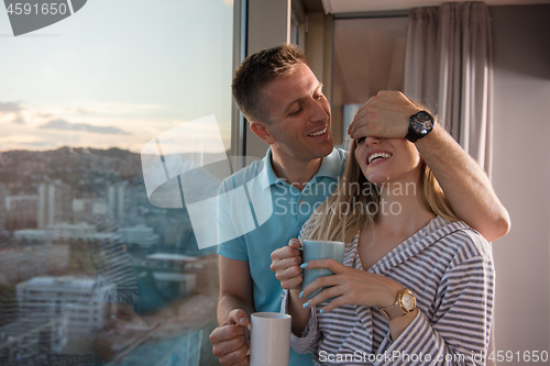 Image of young couple enjoying evening coffee by the window