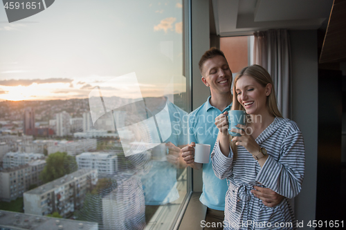 Image of young couple enjoying evening coffee by the window