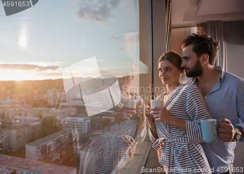 Image of young couple enjoying evening coffee by the window