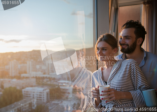 Image of young couple enjoying evening coffee by the window