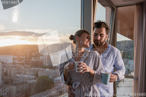 Image of young couple enjoying evening coffee by the window