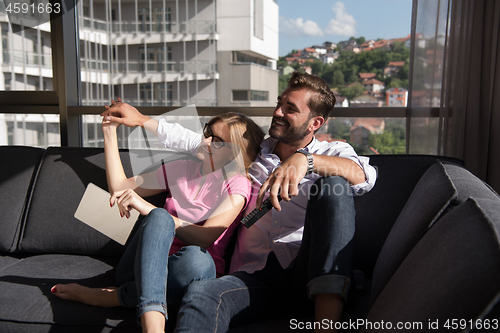 Image of Young couple watching television