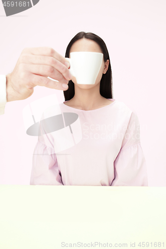 Image of The coffee break concept. woman before drinking coffee sitting indoor at table at studio