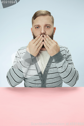 Image of Young man covering mouth by hands