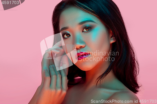 Image of High Fashion model woman in colorful bright lights posing in studio