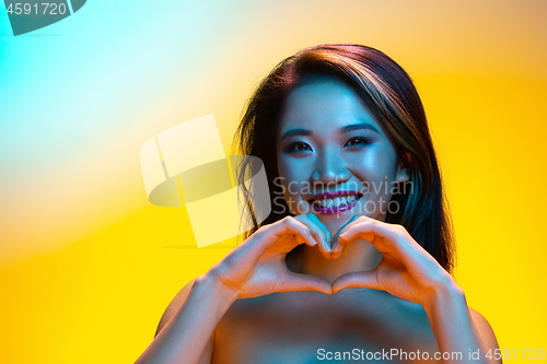 Image of High Fashion model woman in colorful bright lights posing in studio