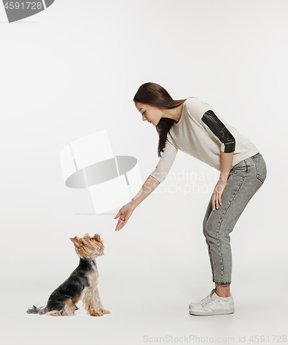 Image of Woman with her dog on leash over white background