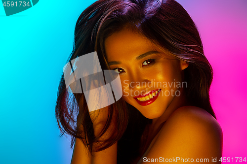 Image of High Fashion model woman in colorful bright lights posing in studio