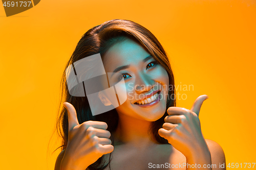 Image of High Fashion model woman in colorful bright lights posing in studio