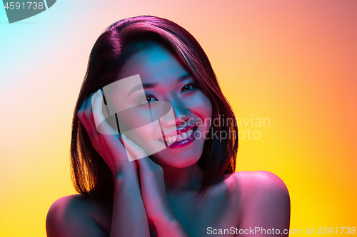 Image of High Fashion model woman in colorful bright lights posing in studio