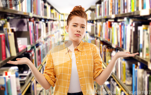 Image of sad red haired student girl shrugging at library