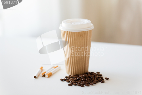 Image of close up of cigarettes, coffee cup and beans