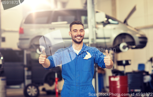 Image of happy auto mechanic man or smith at car workshop