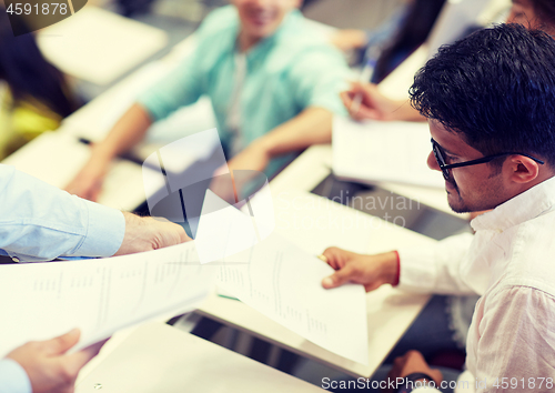 Image of teacher giving exam test to student man at lecture