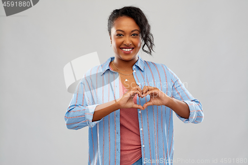 Image of african american woman making hand heart gesture