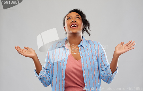 Image of grateful african american woman looking up