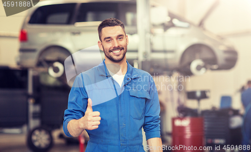 Image of happy auto mechanic man or smith at car workshop