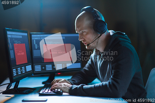 Image of hacker with access denied messages on computers