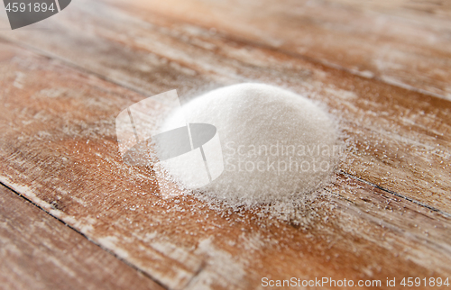 Image of close up of white sugar heap on wooden table