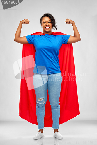 Image of happy african american woman in superhero red cape