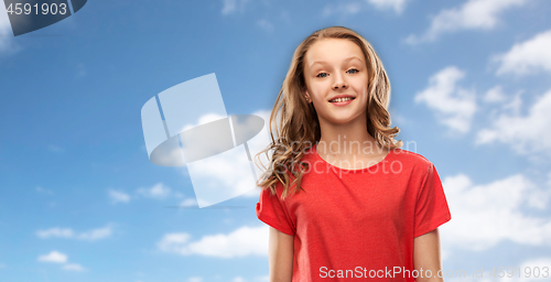 Image of smiling teenage girl in red t-shirt over sky