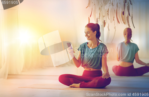 Image of woman with smartphone at yoga studio