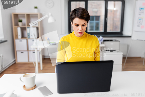 Image of businesswoman with laptop working at office