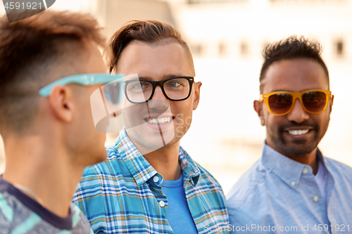 Image of happy young men in glasses and sunglasses outdoors