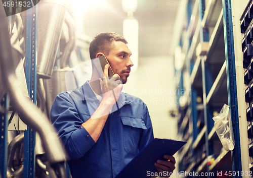 Image of auto mechanic with clipboard at car workshop