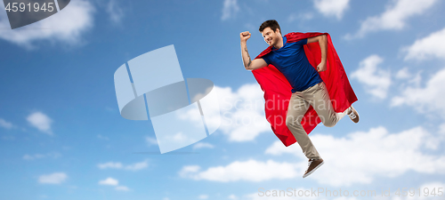 Image of man in red superhero cape flying over sky