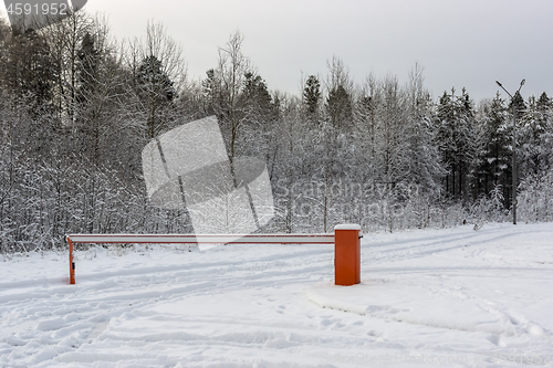 Image of Barrier blocked the car passage on some terrain in winter snowy forest