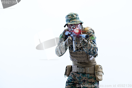 Image of soldier in action aiming laseer sight optics