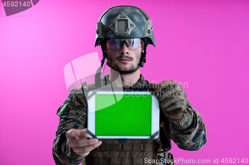 Image of soldier showing a tablet with a blank green screen