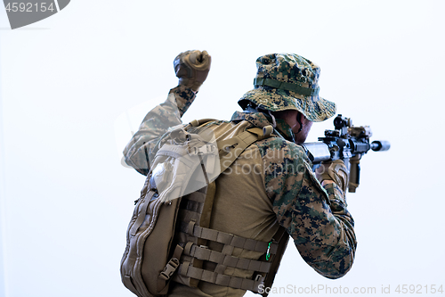 Image of soldier in action giving comands to team by hand sign