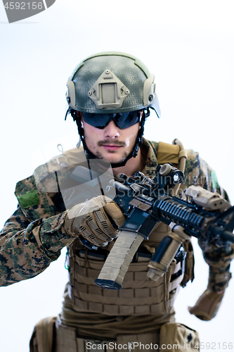 Image of soldier in action aiming laseer sight optics