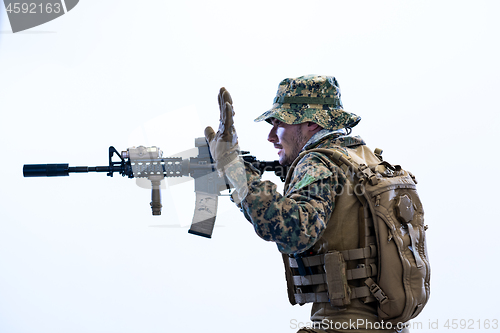 Image of soldier in action aiming laseer sight optics