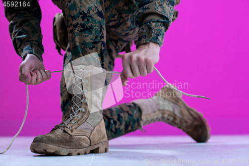 Image of soldier tying the laces on his boots