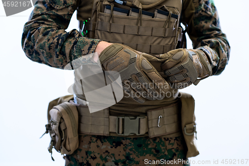 Image of closeup of soldier hands putting protective battle gloves