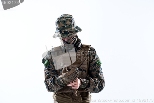 Image of closeup of soldier hands putting protective battle gloves